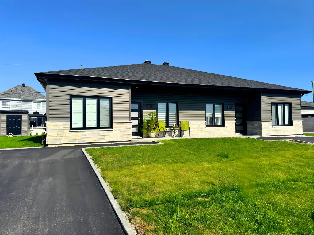 Façade d'une résidence pour retraités aux Résidences Haziel à Chicoutimi — revêtement taupe, pierre calcaire, fenêtres noires